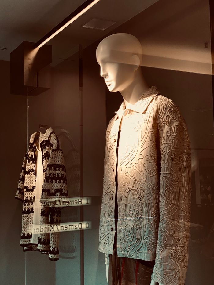 services-02 Stylish retail window display featuring mannequins in patterned jackets.