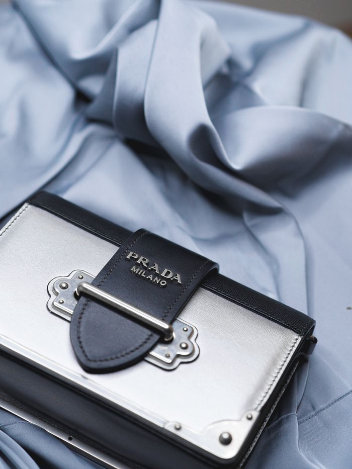 gallery-1 High-end Prada handbag on elegant fabric backdrop, showcasing luxury fashion.