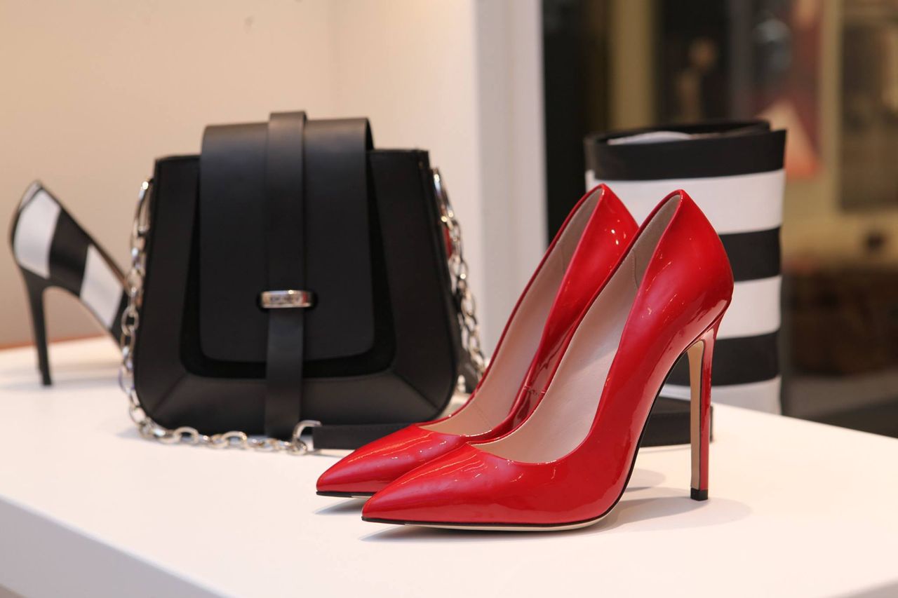 services-03 Showcasing sleek red stilettos and a chic black handbag in a luxury boutique setting.