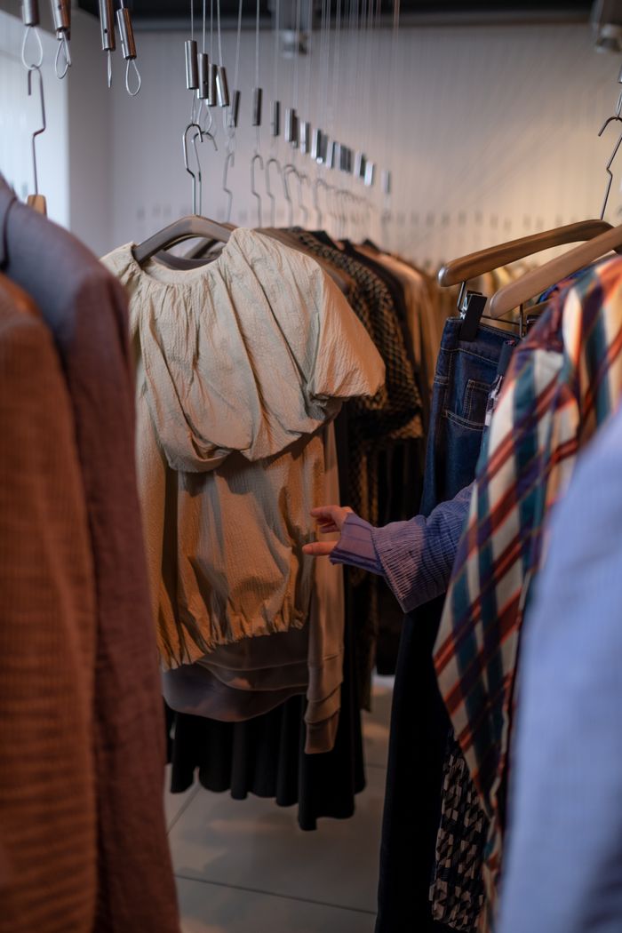 gallery-2 Explore this intimate view of a clothing rack in a modern fashion boutique, showcasing diverse apparel.